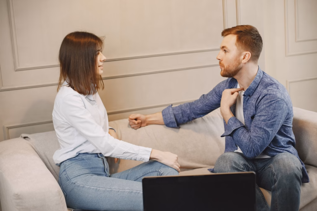How to Stop Arguing in a Relationship: 8 Ways to Break the Cycle 3 A couple talking together on a couch at home