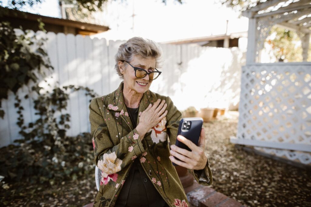 How Often Should Couples Text? Find a Rhythm That Works for Both of You 2 A woman smiling during a video call in her garden