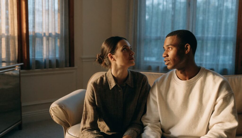 How to Overcome Insecurity in a Relationship: 7 Practical Steps 2 A man and woman sit together on a sofa, sharing a calm conversation.